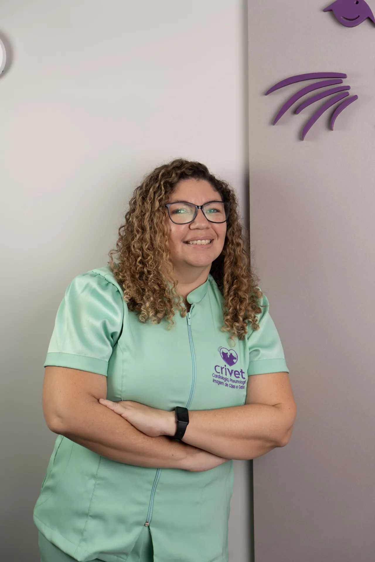 Dra. Cris de braços cruzados na clínica